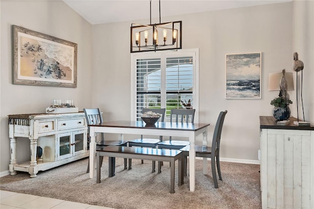 carpeted dining area with an inviting chandelier and lofted ceiling