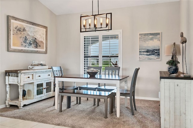 carpeted dining room with an inviting chandelier