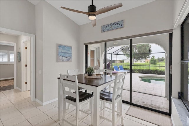 dining room featuring light tile patterned flooring, high vaulted ceiling, and ceiling fan