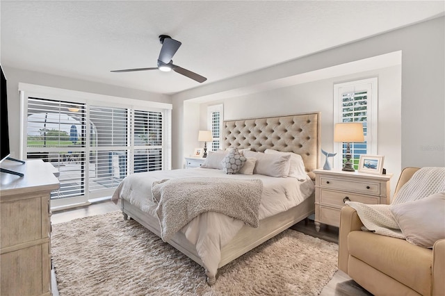 bedroom featuring ceiling fan, access to exterior, light hardwood / wood-style flooring, and a textured ceiling