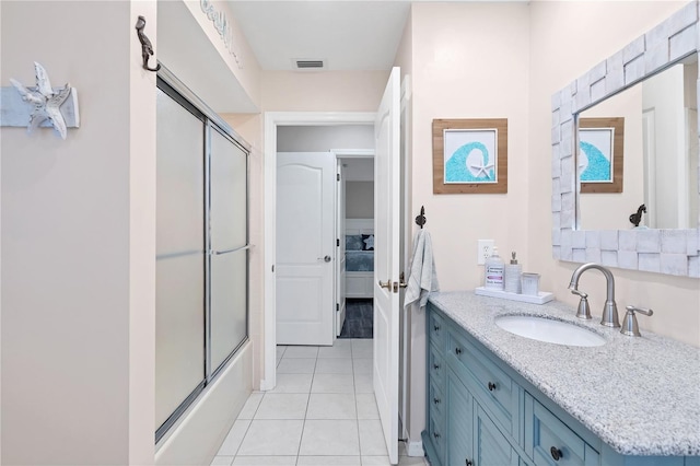 bathroom with combined bath / shower with glass door, tile patterned floors, and vanity