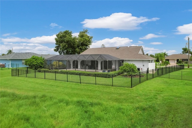 rear view of house with a yard and a lanai