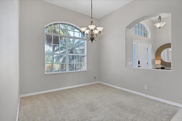 empty room with arched walkways, an inviting chandelier, carpet flooring, and baseboards