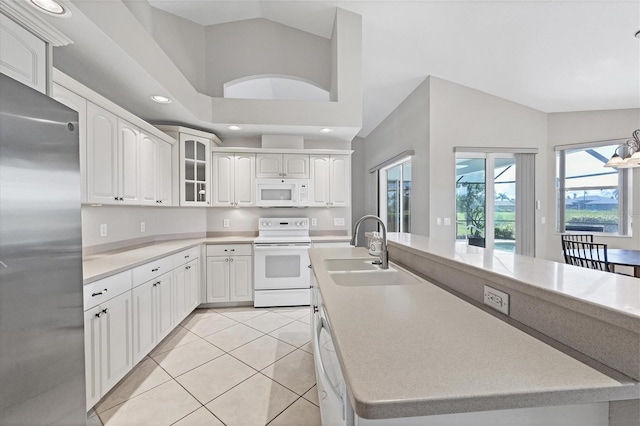 kitchen with white appliances, white cabinets, glass insert cabinets, light countertops, and light tile patterned flooring