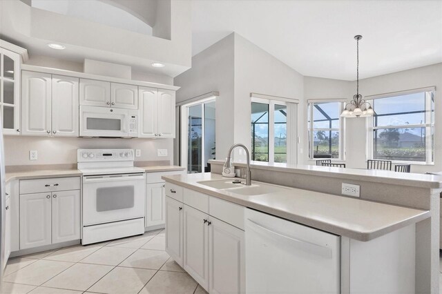 kitchen featuring sink, white appliances, white cabinetry, a notable chandelier, and vaulted ceiling