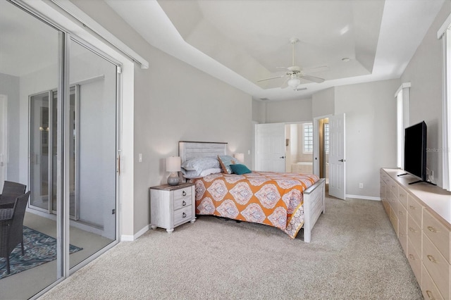 carpeted bedroom featuring ceiling fan, a raised ceiling, and access to outside