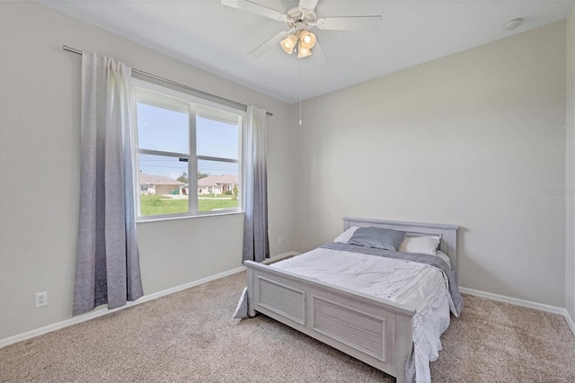 bedroom with a ceiling fan, light colored carpet, and baseboards