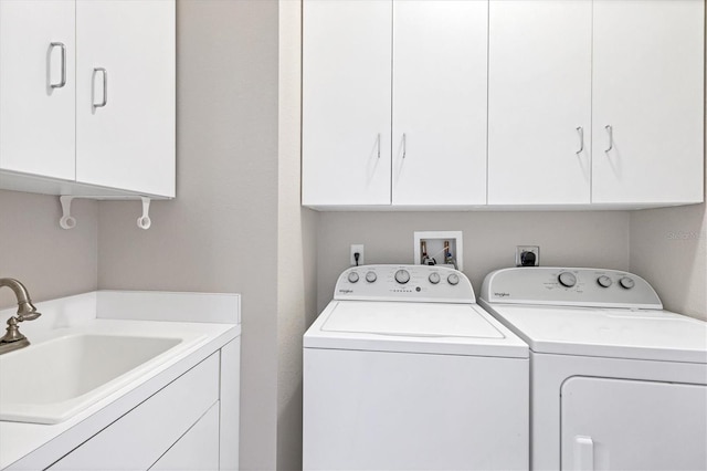 washroom with cabinets, sink, and washing machine and dryer