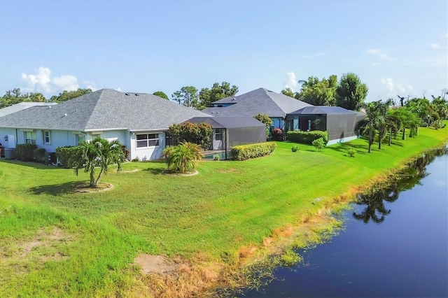 rear view of house with a yard and a lanai