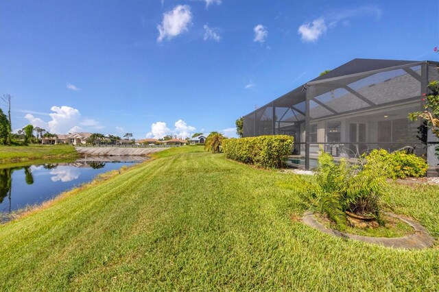 view of yard featuring a water view and glass enclosure