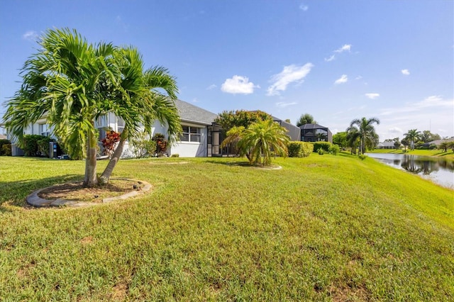 view of yard with a water view and a lanai