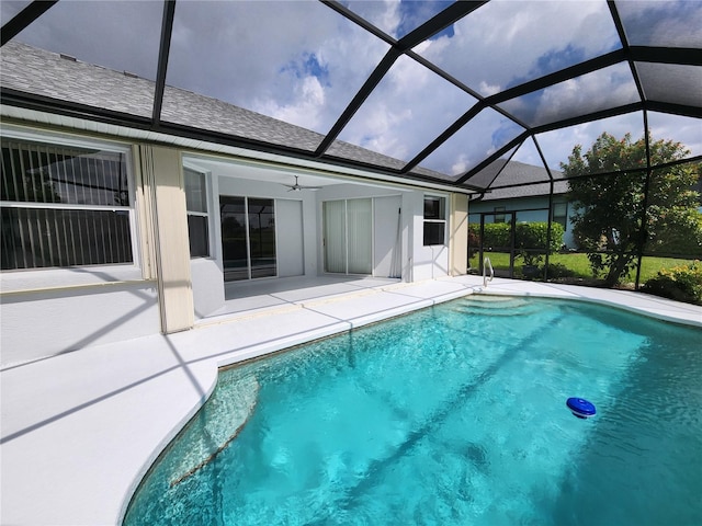 pool featuring ceiling fan, glass enclosure, and a patio