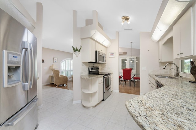 kitchen featuring white cabinetry, tasteful backsplash, stainless steel appliances, light hardwood / wood-style floors, and sink