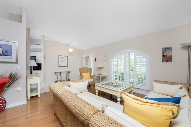 living room featuring light hardwood / wood-style flooring and vaulted ceiling