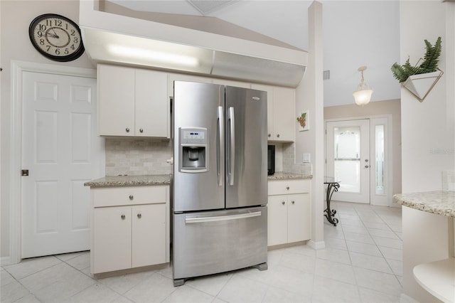 kitchen with light tile patterned flooring, hanging light fixtures, white cabinets, decorative backsplash, and stainless steel fridge with ice dispenser