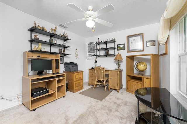 carpeted office space featuring ceiling fan