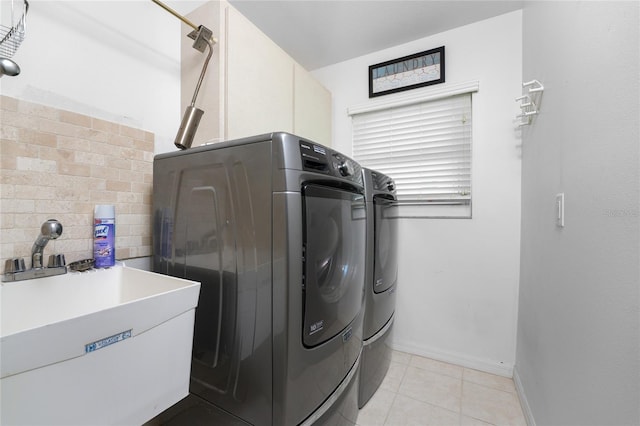 washroom featuring washing machine and clothes dryer, sink, and light tile patterned floors