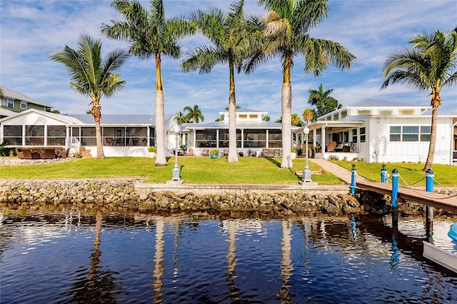 exterior space with a water view and a lawn