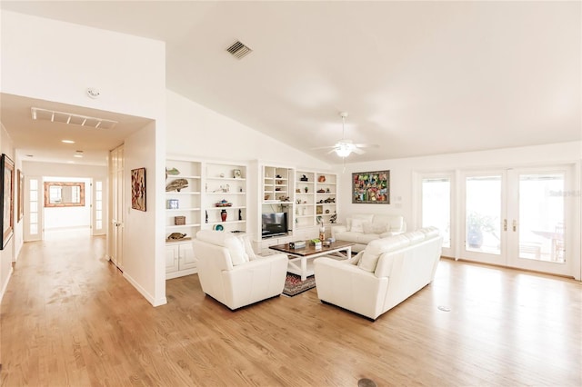 living room featuring french doors, built in features, ceiling fan, light hardwood / wood-style floors, and vaulted ceiling