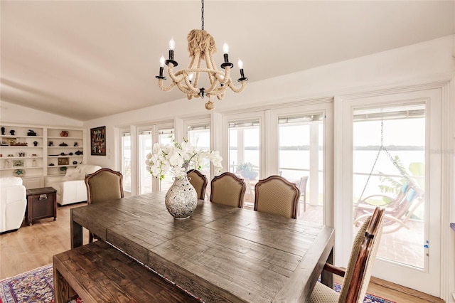 dining room with light hardwood / wood-style floors, a healthy amount of sunlight, and a chandelier