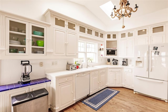 kitchen featuring a chandelier, light wood-type flooring, white appliances, and vaulted ceiling