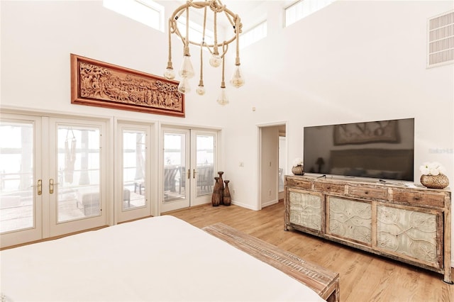 bedroom featuring access to outside, french doors, and light hardwood / wood-style flooring