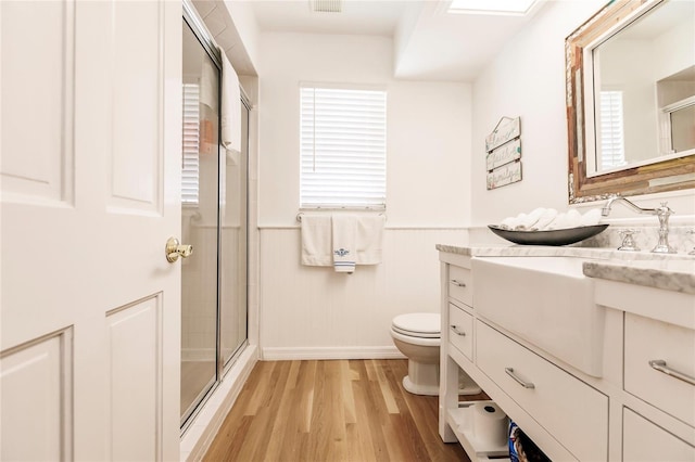 bathroom featuring vanity, an enclosed shower, wood-type flooring, and toilet