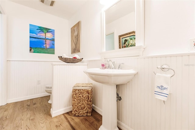 bathroom with wood-type flooring and toilet