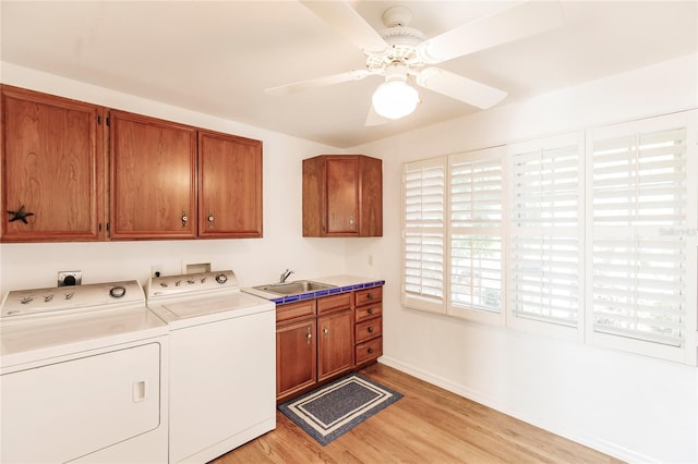 laundry area with ceiling fan, sink, light hardwood / wood-style floors, cabinets, and independent washer and dryer