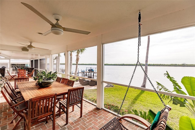 sunroom / solarium with a water view and ceiling fan