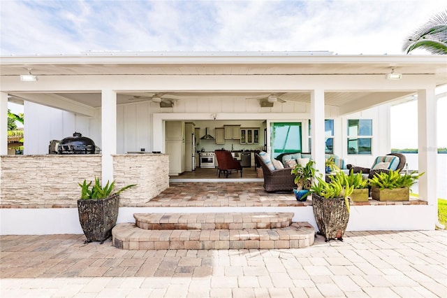 view of exterior entry with ceiling fan and a patio area