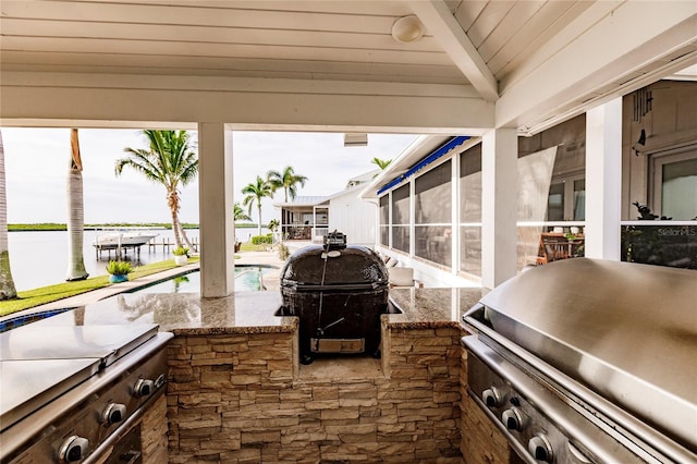 view of patio / terrace with area for grilling, a water view, and grilling area