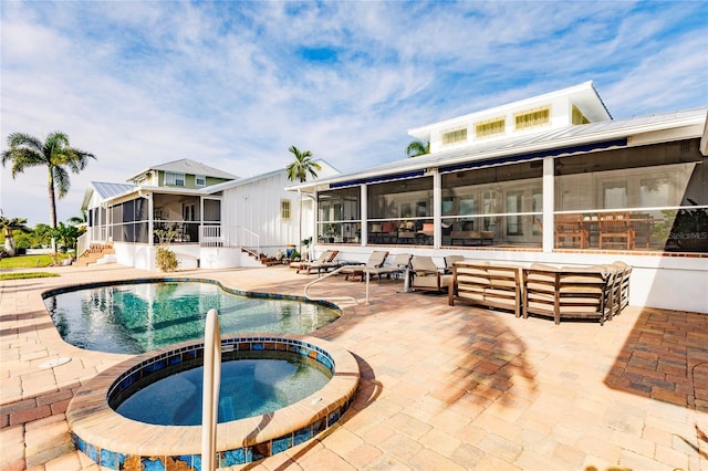 view of pool with an in ground hot tub, a patio area, and a sunroom