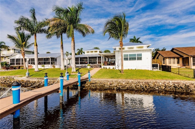 view of dock with a water view and a lawn