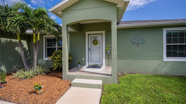 view of exterior entry with stucco siding