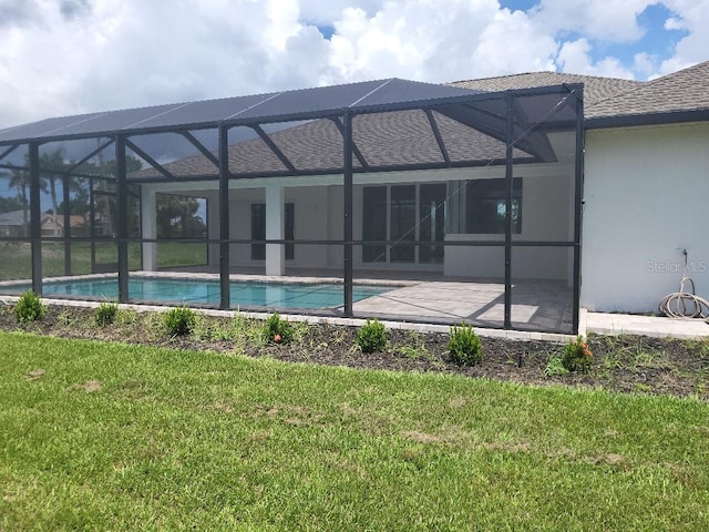 261 Broadmoor Ln, Rotonda West, FL 33947 - rear view of property featuring roof with shingles, stucco siding, a lawn, an outdoor pool, and a patio area