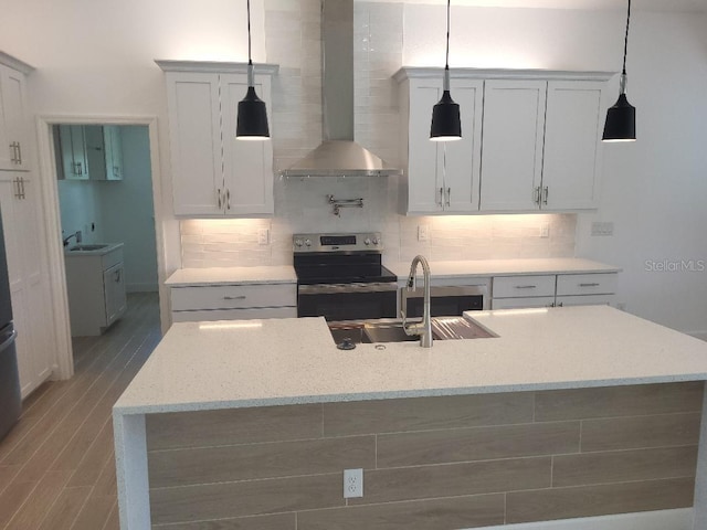 261 Broadmoor Ln, Rotonda West, FL 33947 - kitchen featuring stainless steel electric range, wall chimney exhaust hood, decorative backsplash, decorative light fixtures, and light stone countertops