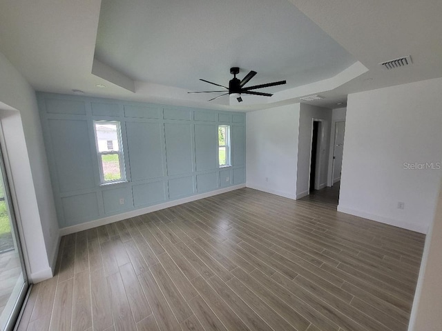 261 Broadmoor Ln, Rotonda West, FL 33947 - spare room with a tray ceiling, a decorative wall, ceiling fan, and wood finished floors