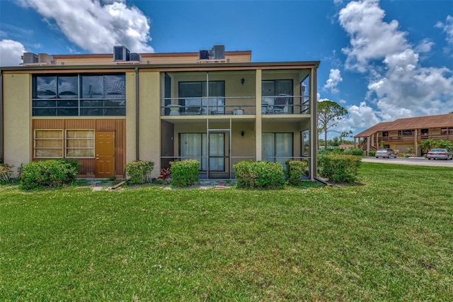 back of property with cooling unit and a lawn