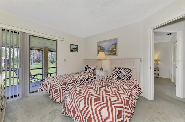 carpeted bedroom featuring access to exterior and a textured ceiling