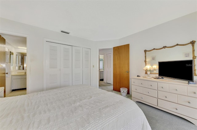 bedroom featuring light carpet, connected bathroom, and a closet