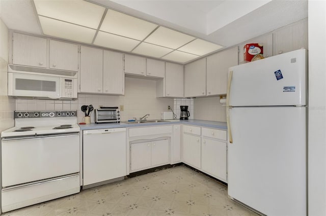 kitchen featuring backsplash, sink, white appliances, and light tile patterned floors