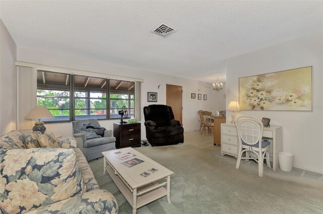 living room featuring a notable chandelier, a textured ceiling, and carpet