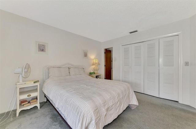 carpeted bedroom with a textured ceiling and a closet