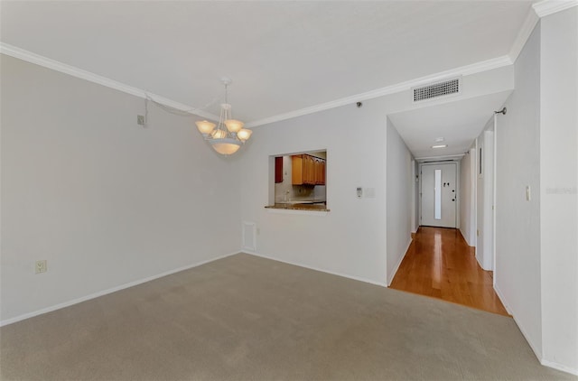 empty room featuring visible vents, crown molding, light carpet, and baseboards