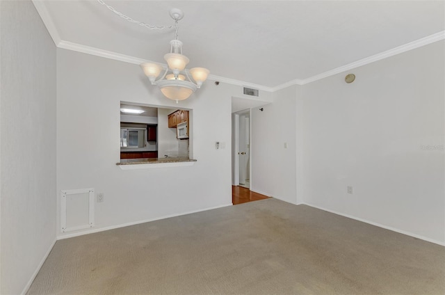 unfurnished room featuring carpet floors, a chandelier, and crown molding