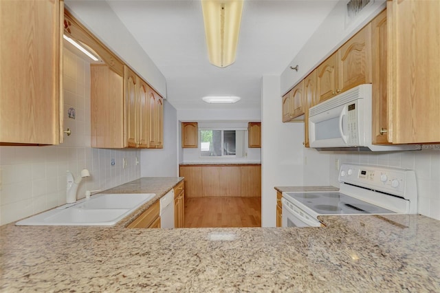 kitchen featuring light hardwood / wood-style flooring, white appliances, light stone countertops, decorative backsplash, and sink