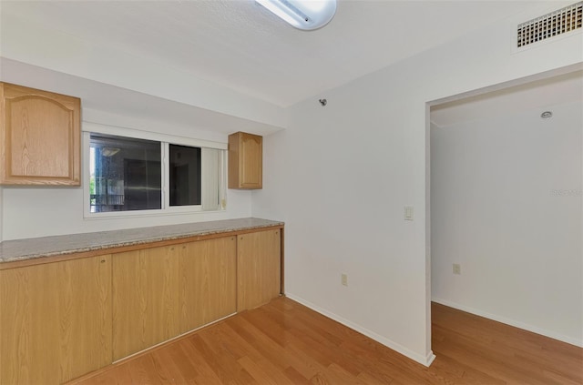 kitchen with light hardwood / wood-style flooring and light brown cabinetry