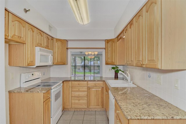 kitchen featuring white appliances, sink, light stone counters, light tile patterned floors, and decorative backsplash