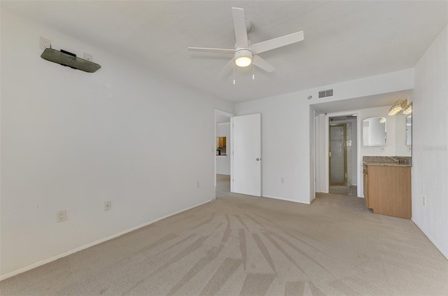 unfurnished bedroom with visible vents, ensuite bathroom, a ceiling fan, and light colored carpet